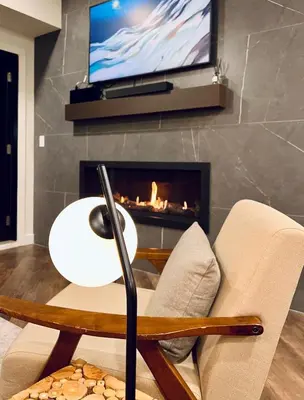 a living room with a fireplace and a tv at New Condo with Pool and Hot Tub Sleeps 9 in Canmore