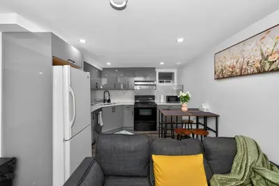a living room with a couch and a kitchen at New 2BR Home - Family Friendly - Near YYC Airport & Downtown - 4412 - DN in Calgary