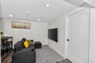 a living room with a couch and a television at New 2BR Home - Family Friendly - Near YYC Airport & Downtown - 4412 - DN in Calgary