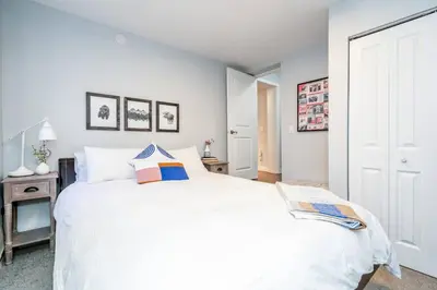 a bedroom with a large white bed and a table at Spacious One Bedroom Queen Bed Inner City Stay in Calgary