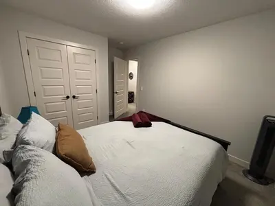 a bedroom with a white bed and a couch at Luxury 4 Bedroom Entire House with Basement in Airdrie