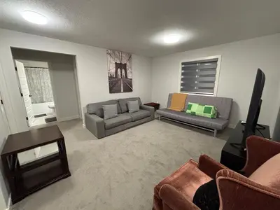 a living room with two couches and a tv at Luxury 4 Bedroom Entire House with Basement in Airdrie