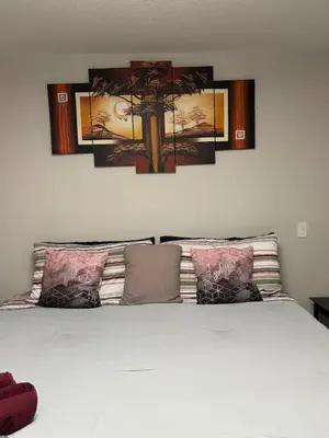 a bedroom with a bed with four pictures on the wall at Luxury 4 Bedroom Entire House with Basement in Airdrie
