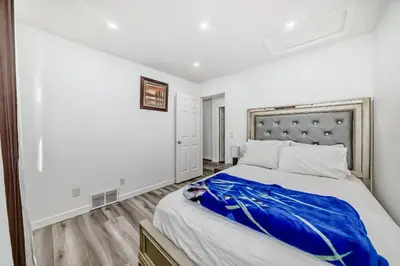 a bedroom with a large bed with a blue blanket at Cozy Vacation Home in Calgary