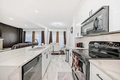 a kitchen with white counter tops and a stove top oven at Cozy Vacation Home in Calgary