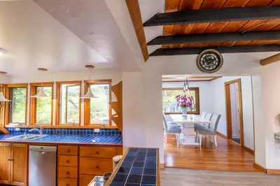 a kitchen with a table and a dining room at Picturesque and Comfy Escape with Waterfall View in Garden Bay