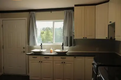 a kitchen with two sinks in front of a window at Creekside Haven on a Sleddog Farm in Dovercourt