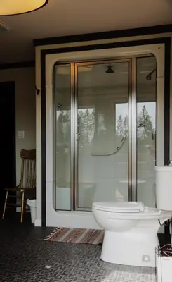 a bathroom with a toilet and a glass shower at Creekside Haven on a Sleddog Farm in Dovercourt