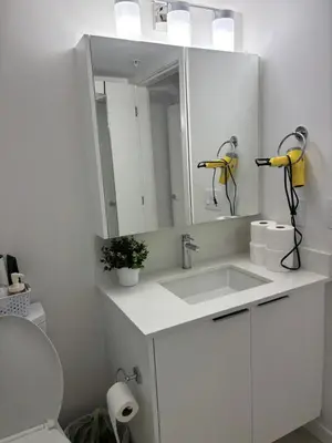 a white bathroom with a sink and a mirror at Cozy 1 bed and 1bath suit in Surrey