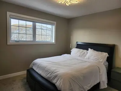 a bedroom with a large bed with a window at Harmony Haven in Drumheller in Drumheller