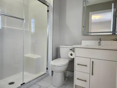 a bathroom with a toilet and a glass shower at Harmony Haven in Drumheller in Drumheller