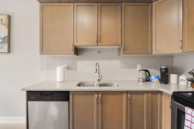 a kitchen with wooden cabinets and a sink at A beautiful home in Airdrie in Airdrie