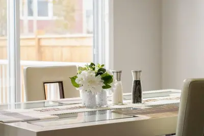 a table with a vase with white flowers on it at A beautiful home in Airdrie in Airdrie
