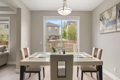 a dining room with a table and chairs and a window at A beautiful home in Airdrie in Airdrie