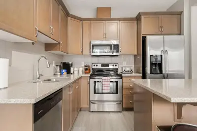a kitchen with stainless steel appliances and wooden cabinets at A beautiful home in Airdrie in Airdrie