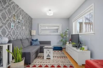 a living room with a couch and a tv at Bright and Open Coziness. 10 minutes to Stampede in Calgary