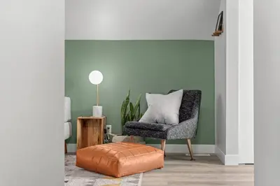 a living room with a chair and a ottoman at Mid Century Zen Suite. 1 BR. Near DT, C-train. in Calgary