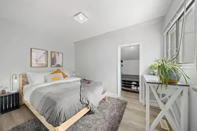 a white bedroom with a bed and a desk at Mid Century Zen Suite. 1 BR. Near DT, C-train. in Calgary