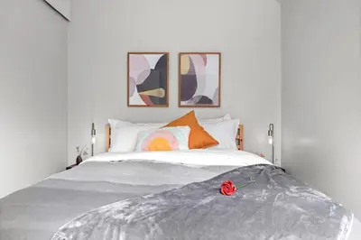 a bedroom with a bed with a rose on it at Mid Century Zen Suite. 1 BR. Near DT, C-train. in Calgary