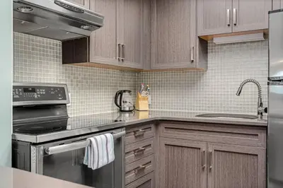 a kitchen with wooden cabinets and stainless steel appliances at Funky 1 BR Century Home-Near DT, C-train in Calgary