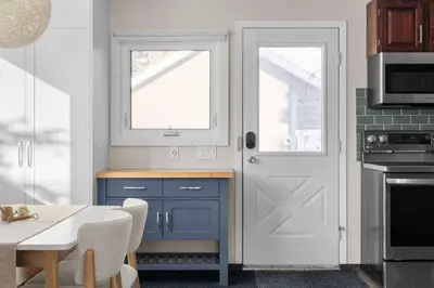 a kitchen with blue cabinets and a white door at Bright and Welcoming Mount Pleasant Home, near DT in Calgary