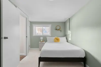 a bedroom with a white bed and a window at Bright and Welcoming Mount Pleasant Home, near DT in Calgary