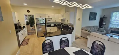 a kitchen and living room with a table and chairs at Premium stay in Metro Vancouver-World Cup ready in Coquitlam