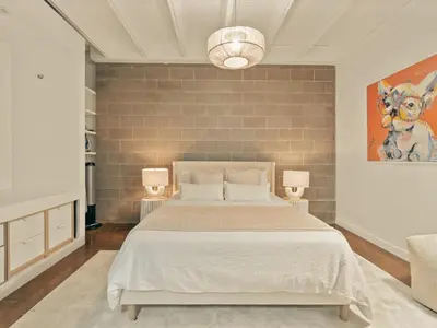 a bedroom with a large bed and two lamps at Luxury 2BR 2BA Loft Ice District W Heated Parking in Edmonton