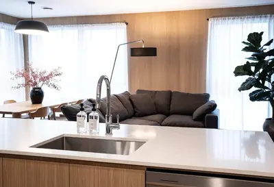 a kitchen with a sink and a couch in a room at Luna Ridge - Thoughtfully Designed 3-Bedroom Condo in Revelstoke