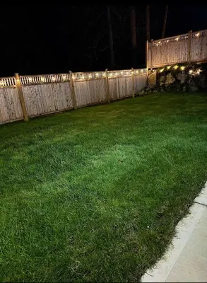 a fence in a yard at night with green grass at Luxury 2-Bedroom Suite at Bear Mountain Victoria in Langford