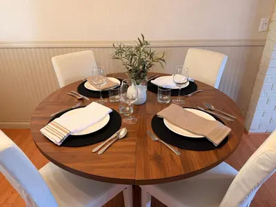 a wooden table with plates and wine glasses on it at Spacious 2 Bedroom Suite in Delta