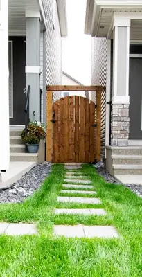 a house with a wooden gate and green grass at Cozy Luxe 1BR Suite in Calgary