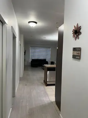 an empty hallway with a living room and a table at 2 Bedroom plus den 2 Bathroom apartment in Surrey