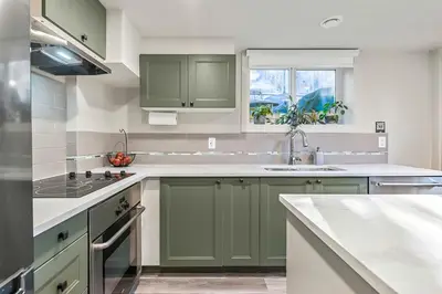 a kitchen with green cabinets and a sink at Bright & Cozy Central Retreat in Calgary