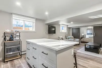 a kitchen with a white counter top and a living room at Bright & Cozy Central Retreat in Calgary