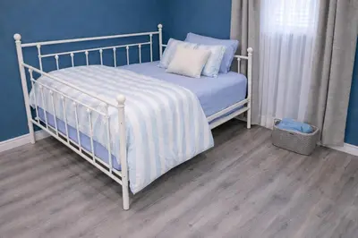 a bedroom with a white bed with blue walls at Home Basement, Friendly Family in Calgary