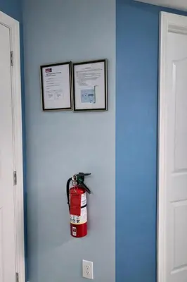 a fire extinguisher hanging on a wall in a room at Home Basement, Friendly Family in Calgary
