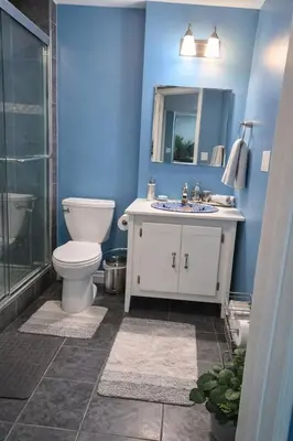 a blue bathroom with a toilet and a sink at Home Basement, Friendly Family in Calgary