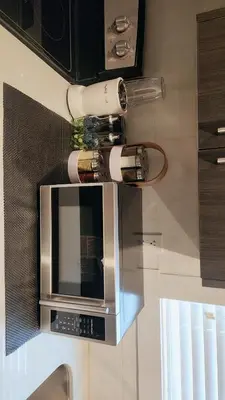 a microwave with wine bottles on top of it at Hebzibah's Luxe in Prince George