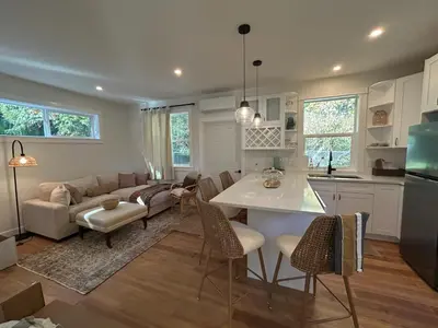 a kitchen and living room with a table and a couch at Retreat to Quail Cottage in Chemainus