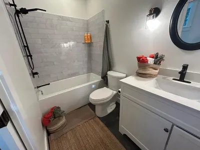 a white bathroom with a sink and a toilet at Retreat to Quail Cottage in Chemainus