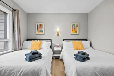two beds in a bedroom with towels on them at Modern House-3BR/Spacious good for 8/Free Parking in Edmonton