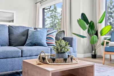 a living room with a blue couch and a table at Modern House-3BR/Spacious good for 8/Free Parking in Edmonton