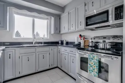 a kitchen with white cabinets and a stove top oven at Edmonton House w/5BR/3BA/2Kitchens & Fenced Yard in Edmonton