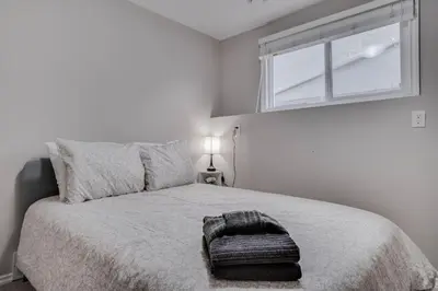 a bedroom with a bed with a ottoman on it at Edmonton House w/5BR/3BA/2Kitchens & Fenced Yard in Edmonton