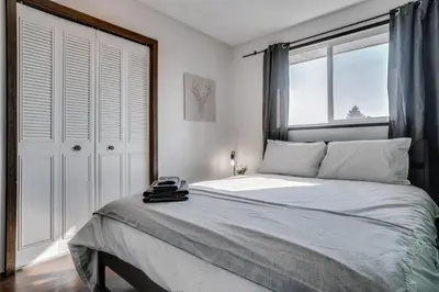 a bedroom with a large bed with a window at Edmonton House w/5BR/3BA/2Kitchens & Fenced Yard in Edmonton