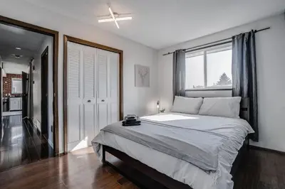 a bedroom with a large bed and a window at Edmonton House w/5BR/3BA/2Kitchens & Fenced Yard in Edmonton