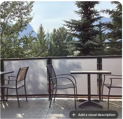 a table and chairs on a balcony with a view at Canmore Mountain View in Canmore