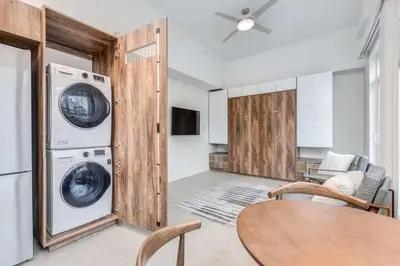 a laundry room with a washer and dryer and a table at Modern Studio Condo in Central Prime Location in Vancouver