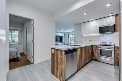 a kitchen with white walls and wooden cabinets at Luxury 2BR Walk to Everything Downtown in Vancouver